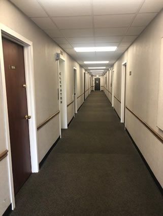 A long hallway with a lot of doors in a building.