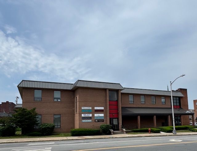 A brick building with a red stripe on the side of it