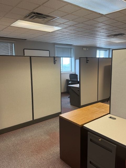 An office with cubicles, desks, and a chair
