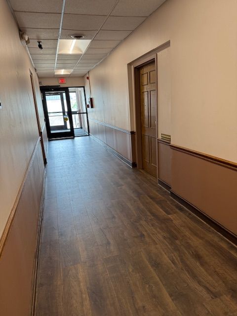 A long hallway with wooden floors and a door