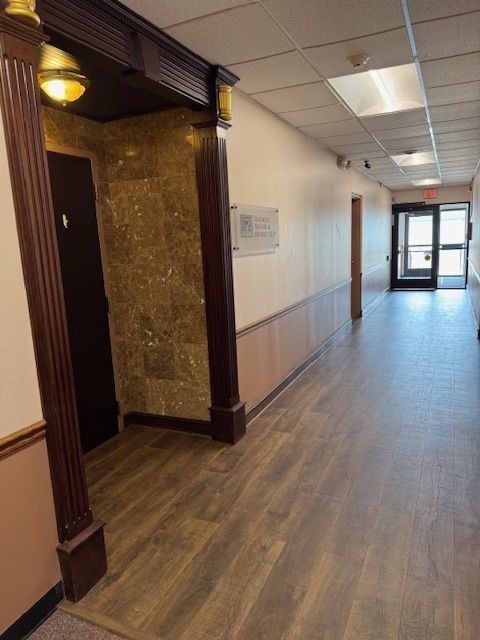 A long hallway with wooden floors and a door
