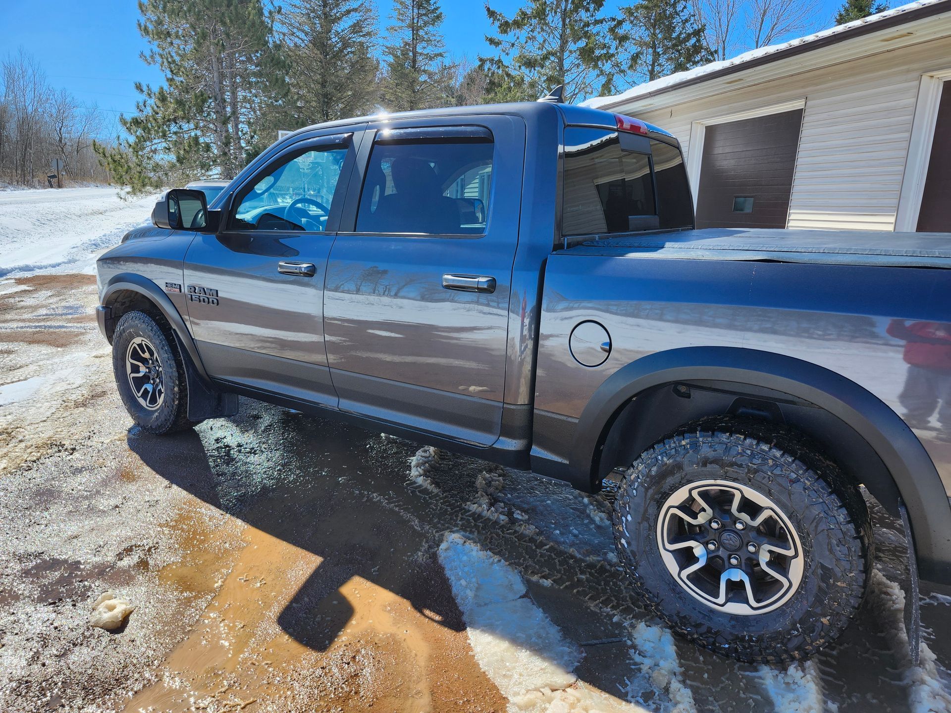 A black truck is parked in front of a garage.