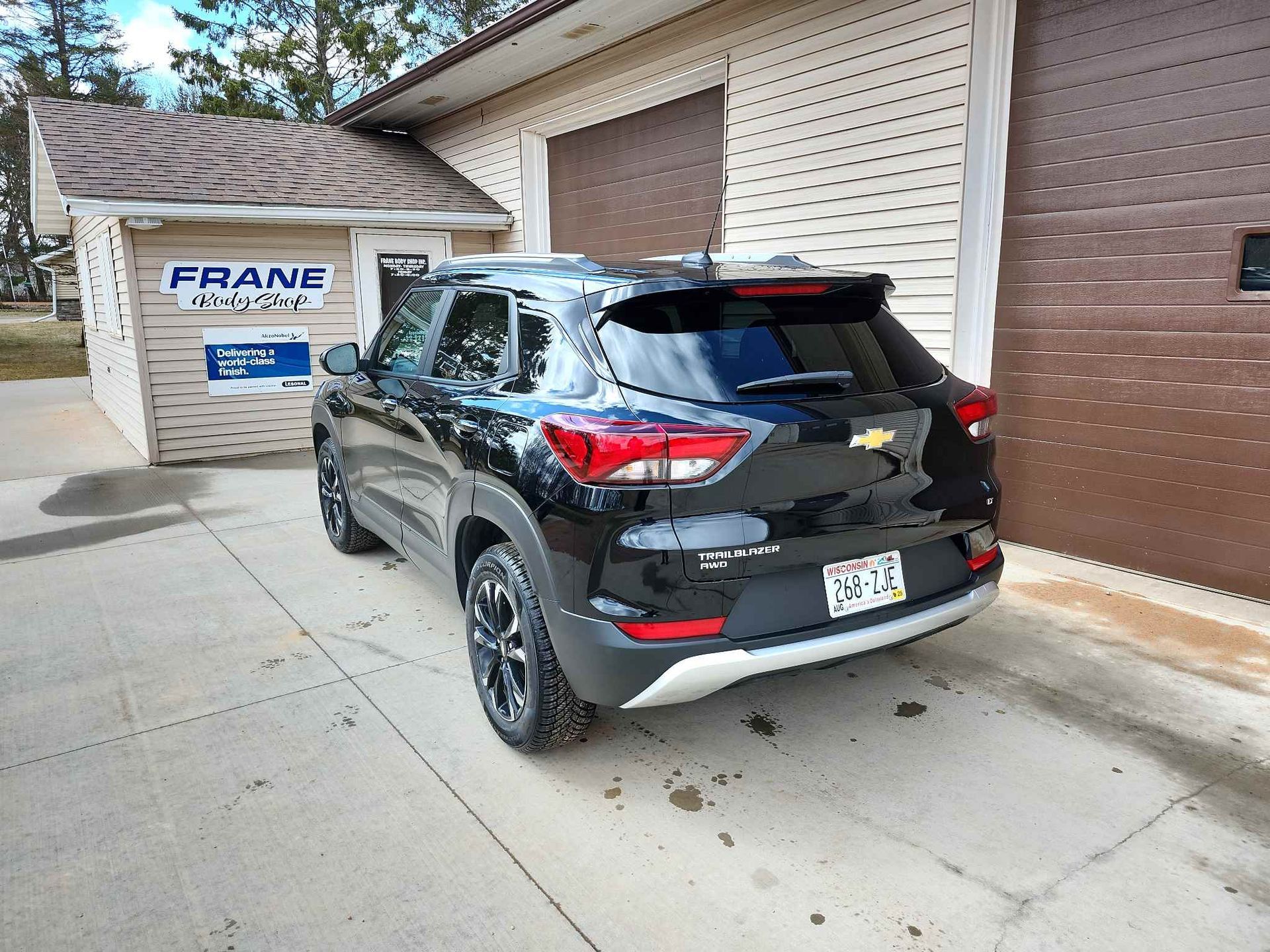A black car is parked in front of a garage.