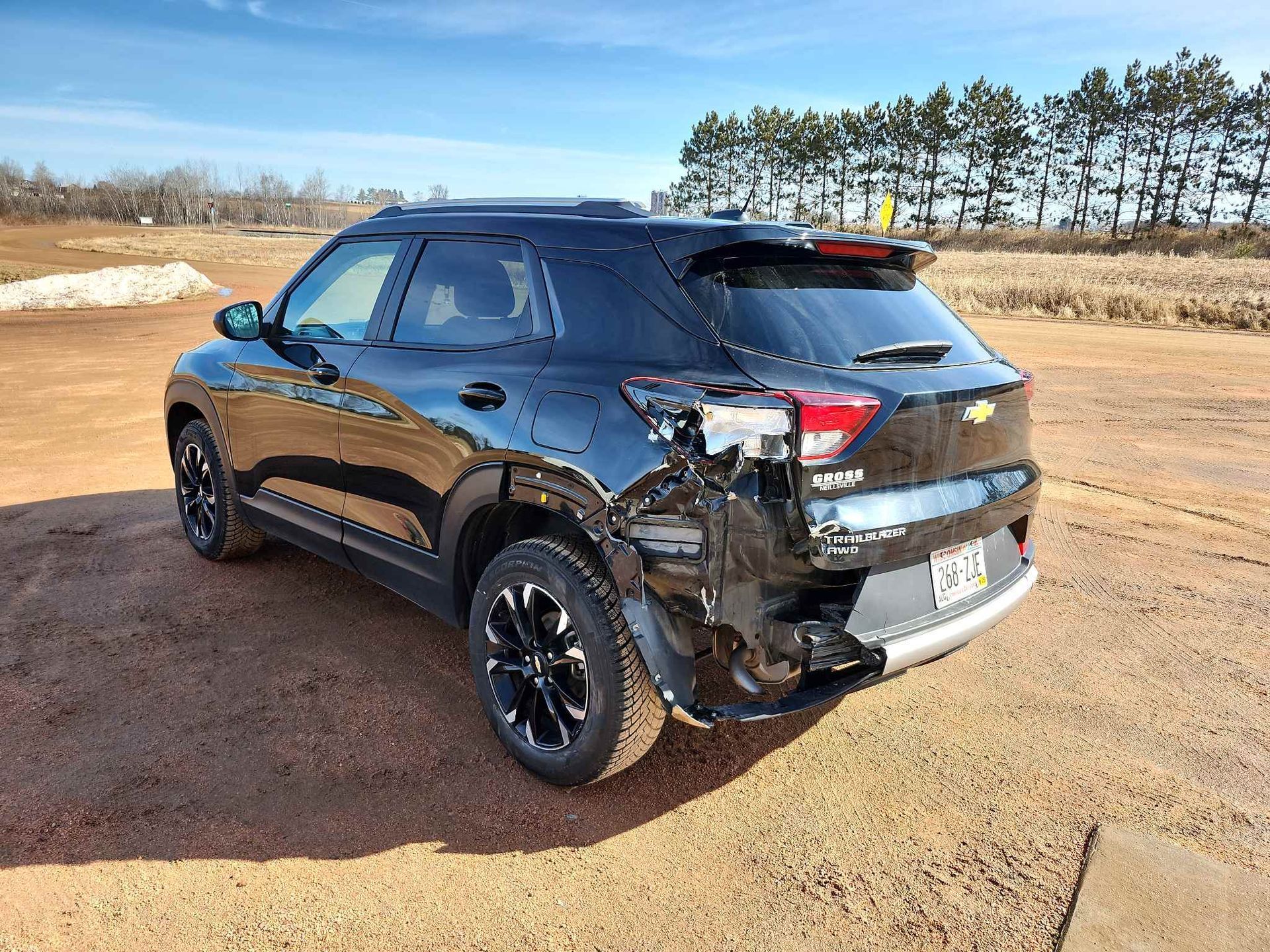 A black Chevrolet trailblazer is parked in a dirt field.