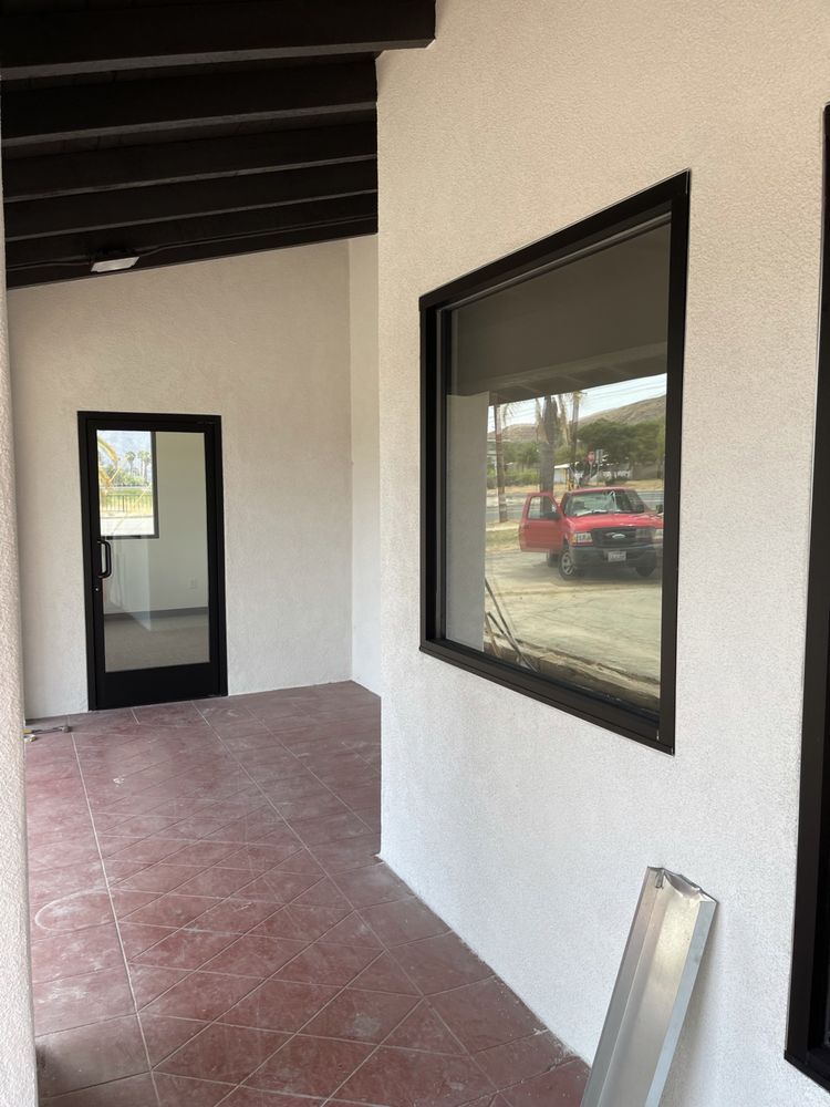 A red truck is reflected in a window in a building