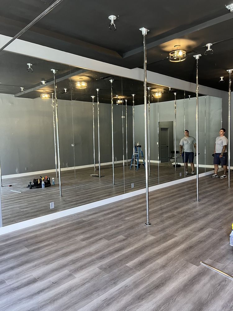A room with a lot of mirrors and poles in it.