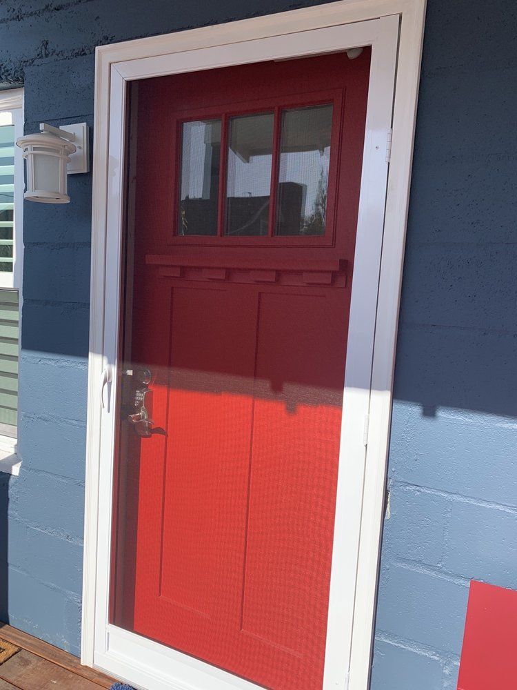 A red door on a blue and white house
