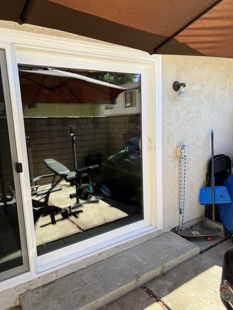 A sliding glass door with a reflection of a gym in it.