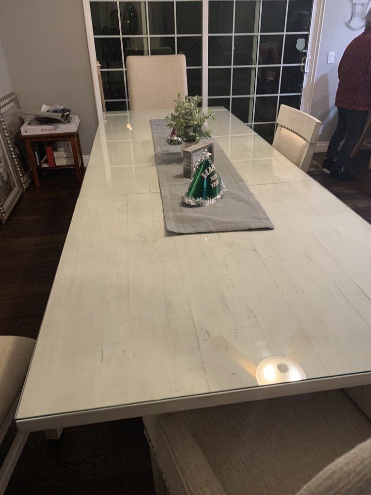 A long white marble dining table with chairs in a dining room.