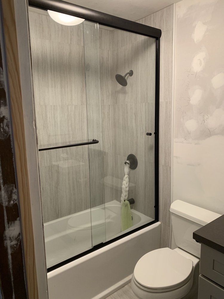 A bathroom with a tub , toilet , and shower.