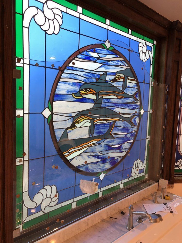 A stained glass window with a picture of a dolphin on it