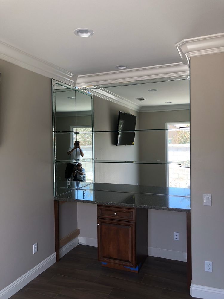 A room with a desk and a television on the wall.