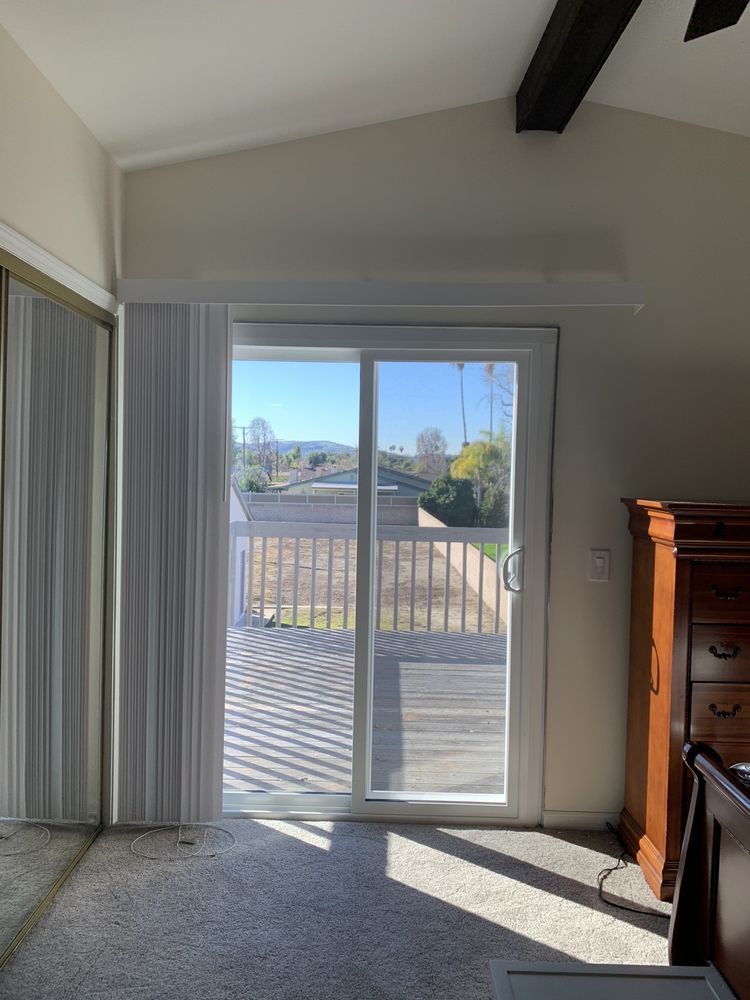 A bedroom with a sliding glass door leading to a deck.