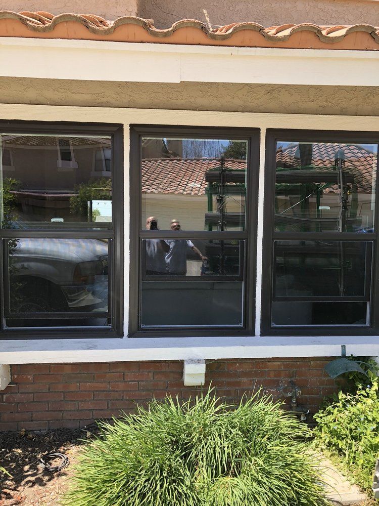 There are three windows on the side of a house.