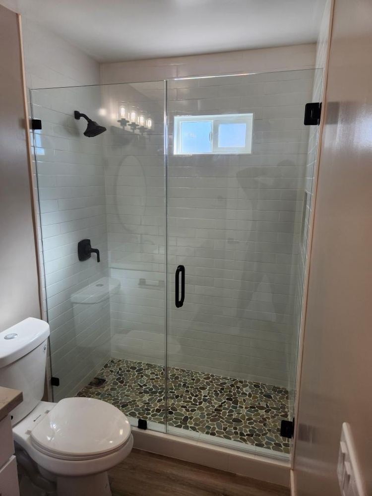 A bathroom with a toilet and a shower with a glass door.