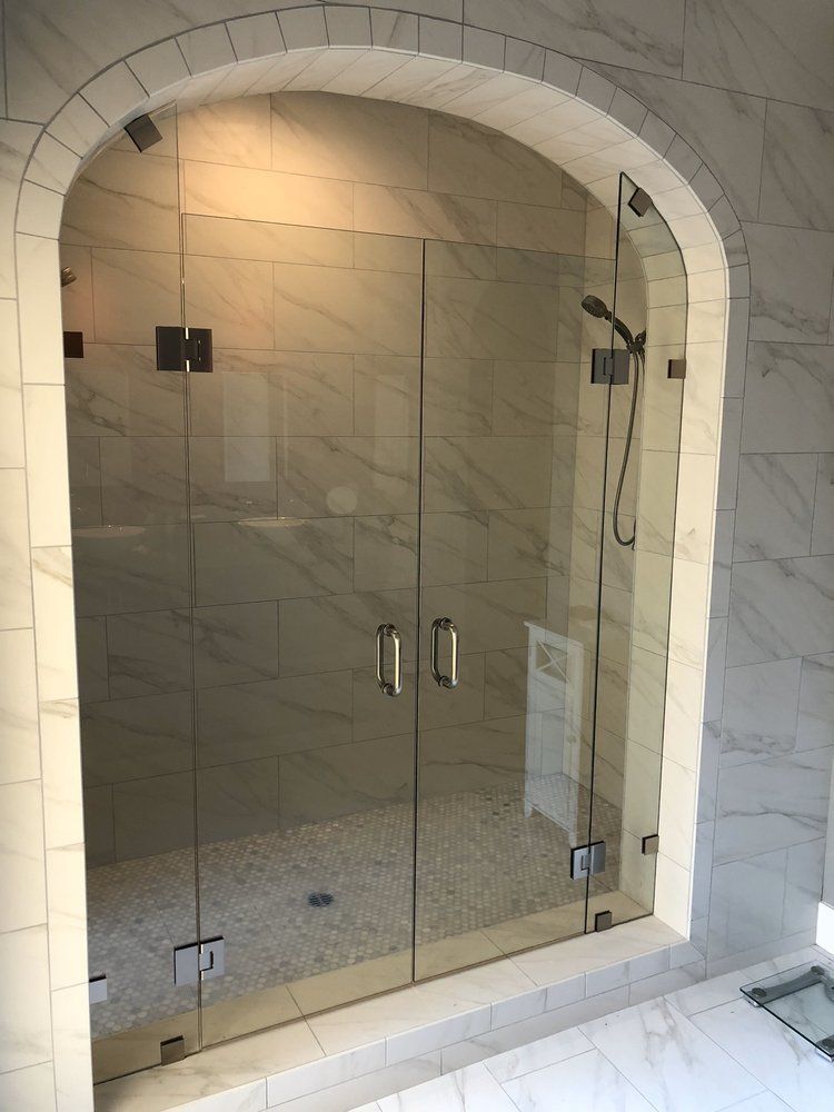 A bathroom with a glass shower door and a shower head.
