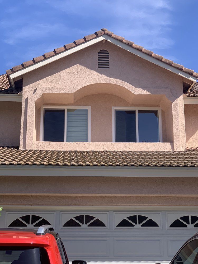 A red truck is parked in front of a house