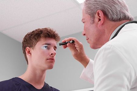 A doctor is examining a man 's eye