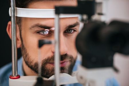 A man is getting his eyes examined by an ophthalmologist.