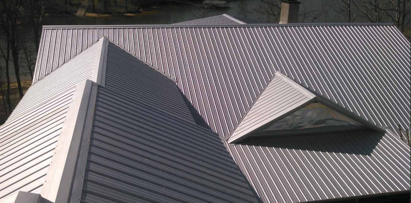 The roof of a house has a triangle window on it.