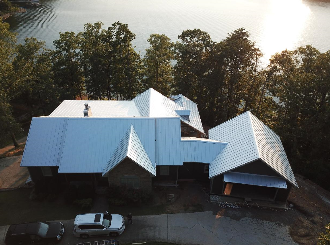 An aerial view of a house with a lake in the background
