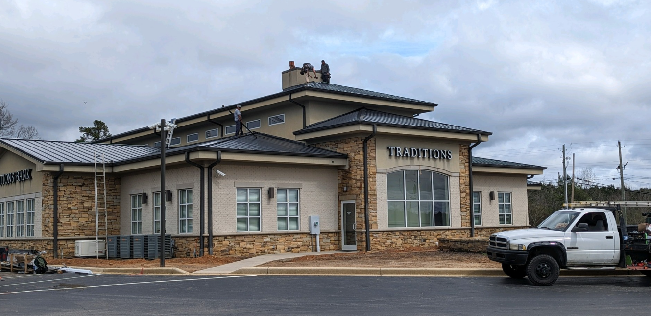 A white truck is parked in front of a large building.