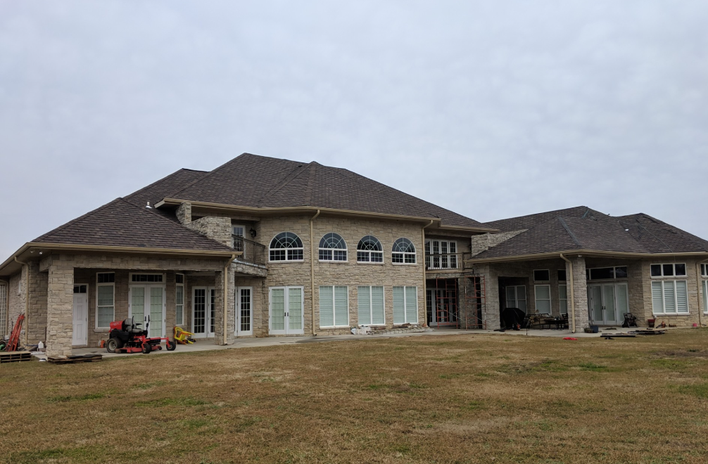 A large house with a large lawn mower parked in front of it.