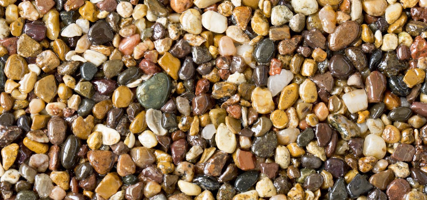 Close-up of a surface covered in small, colorful, smooth pebbles.