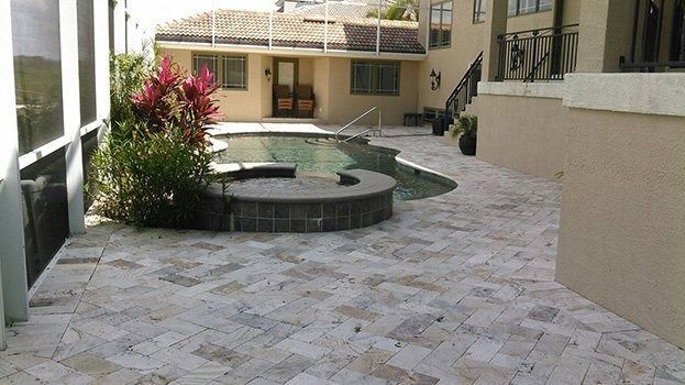 Courtyard patio with stone paving, circular hot tub, and surrounding apartment buildings.