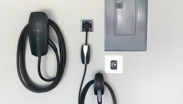 There is a tesla charging station on the wall.