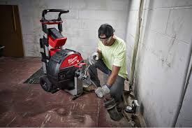 man doing drain cleaning on a basement drain