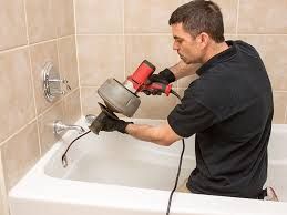 image of a man doing drain cleaning in a tub