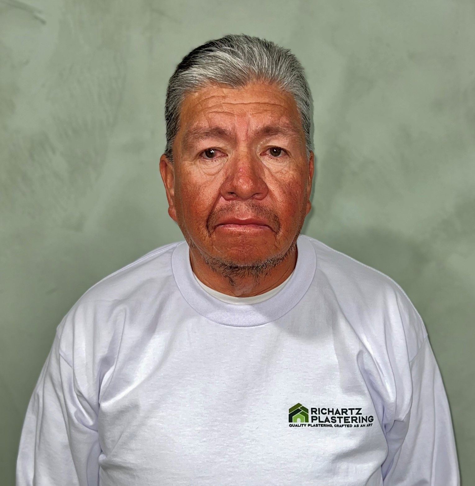 Portrait of a man in a white shirt against a plain gray background