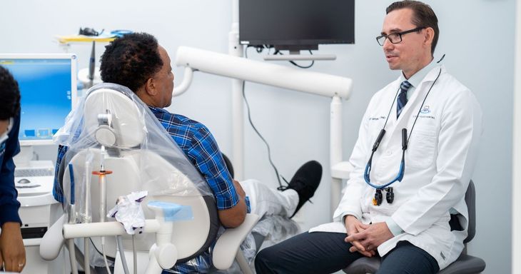 A woman is getting her teeth examined by a dentist.