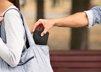 Thief stealing wallet from woman handbag