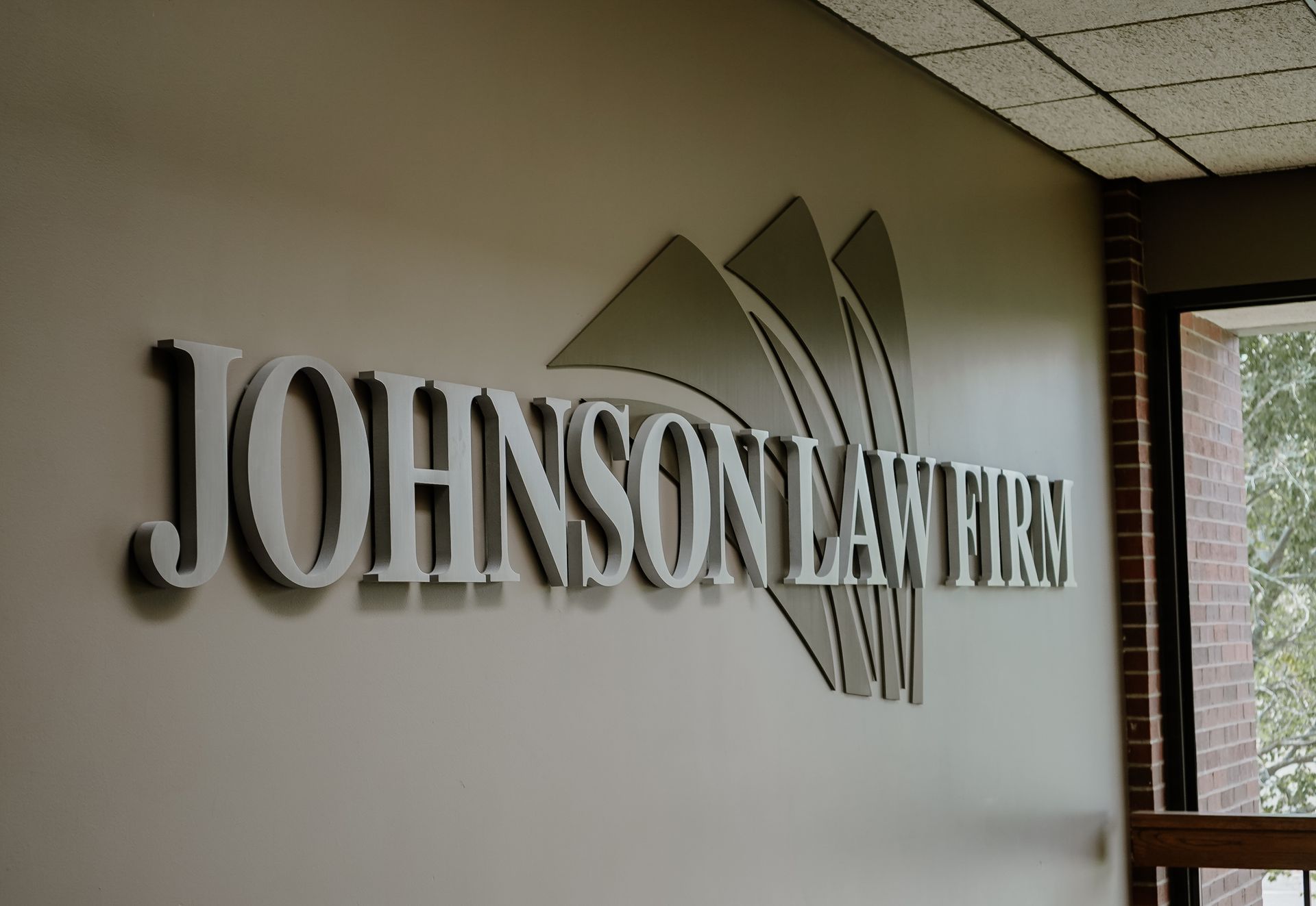 Johnson Law Firm wall sign in metallic letters inside an office hallway