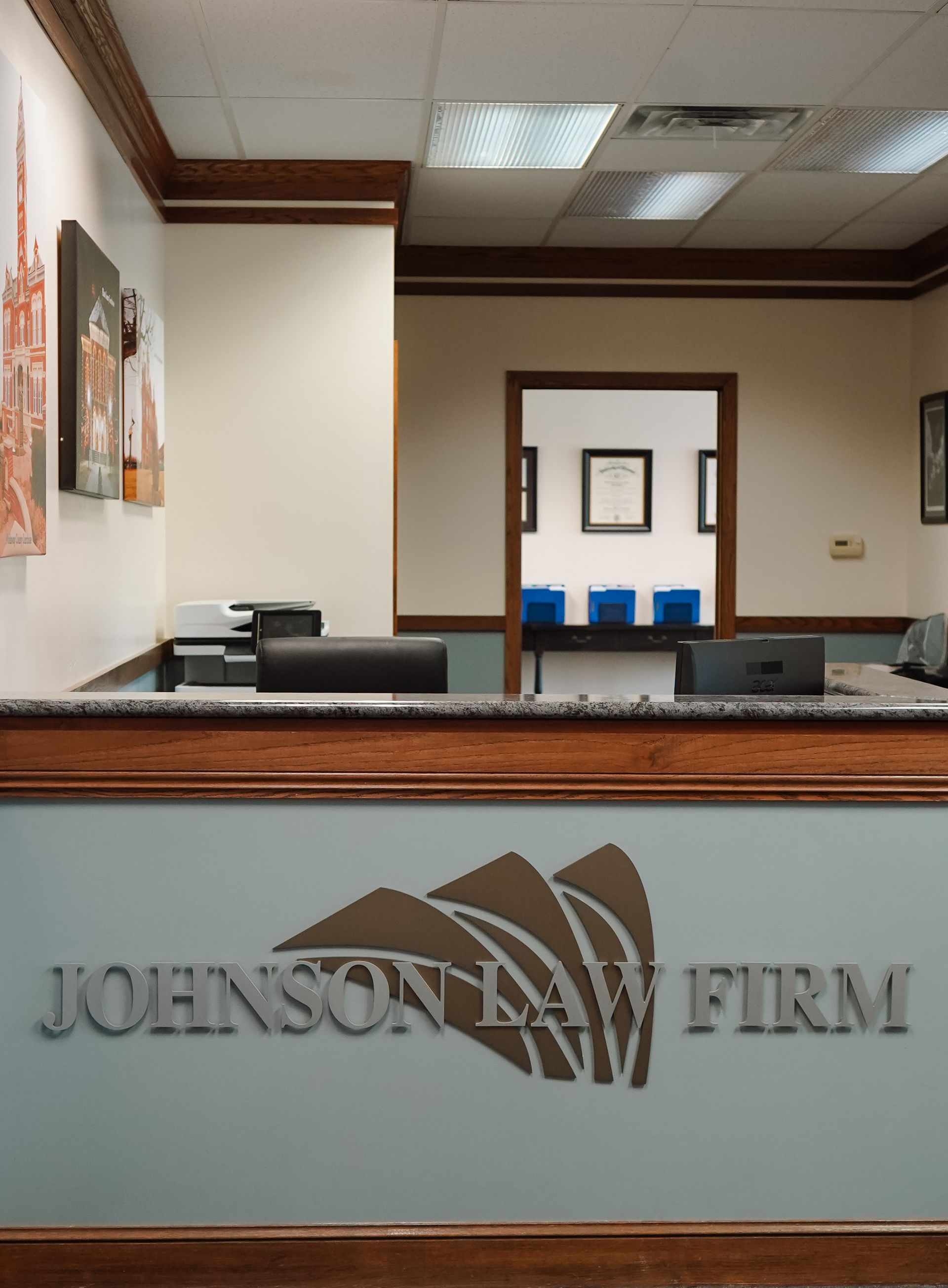 Johnson Law Firm reception desk with frosted glass sign and lobby interior behind it