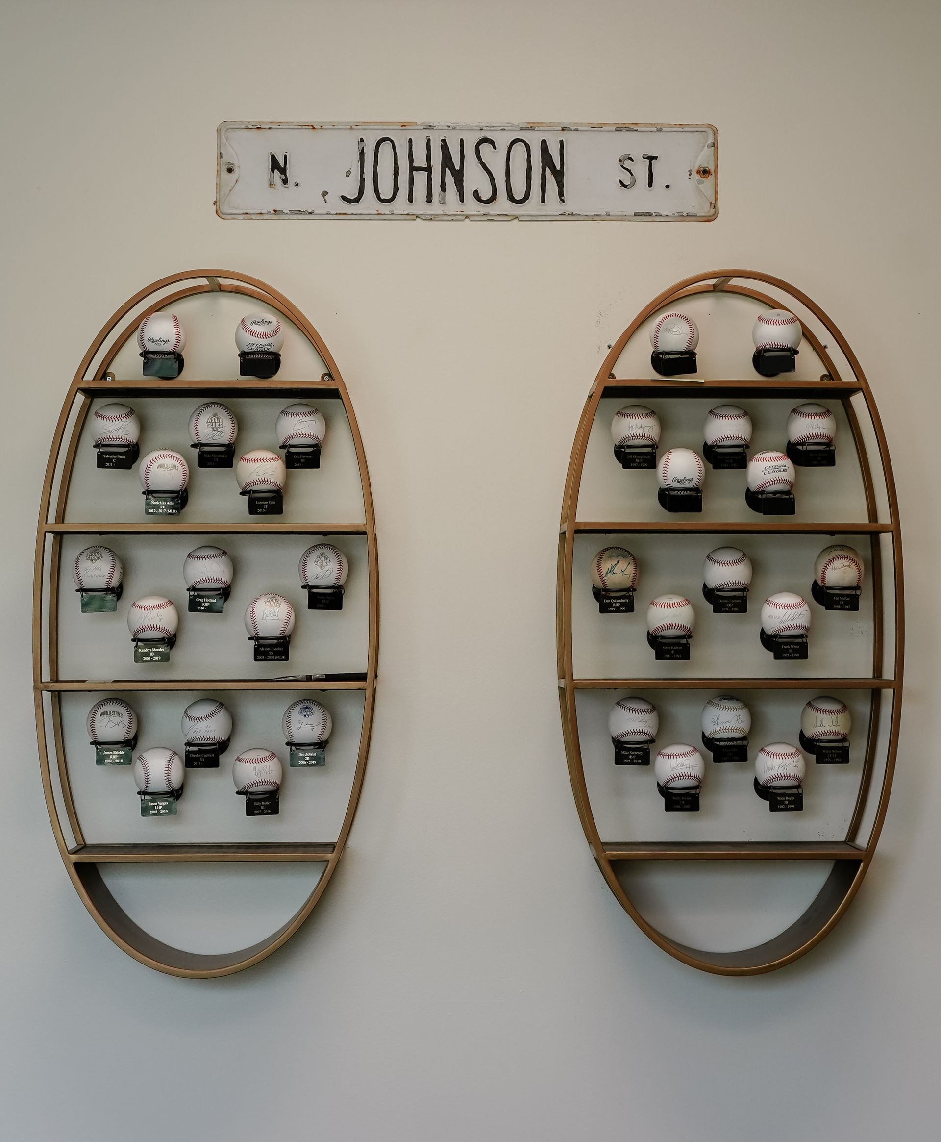 Wall-mounted sign reading “N. Johnson St.” above two oval shelves holding small white cups or mugs.