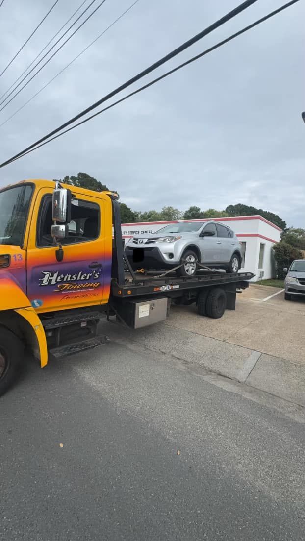 A tow truck is carrying a car on the back of it.