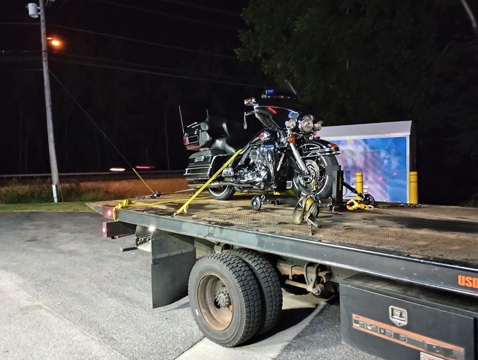 Two motorcycles are sitting on top of a flatbed tow truck.