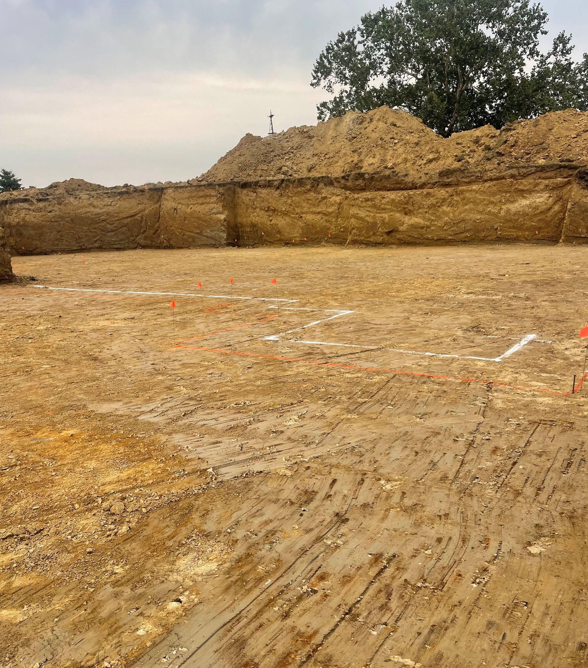 A large pile of dirt is sitting in the middle of a dirt field.