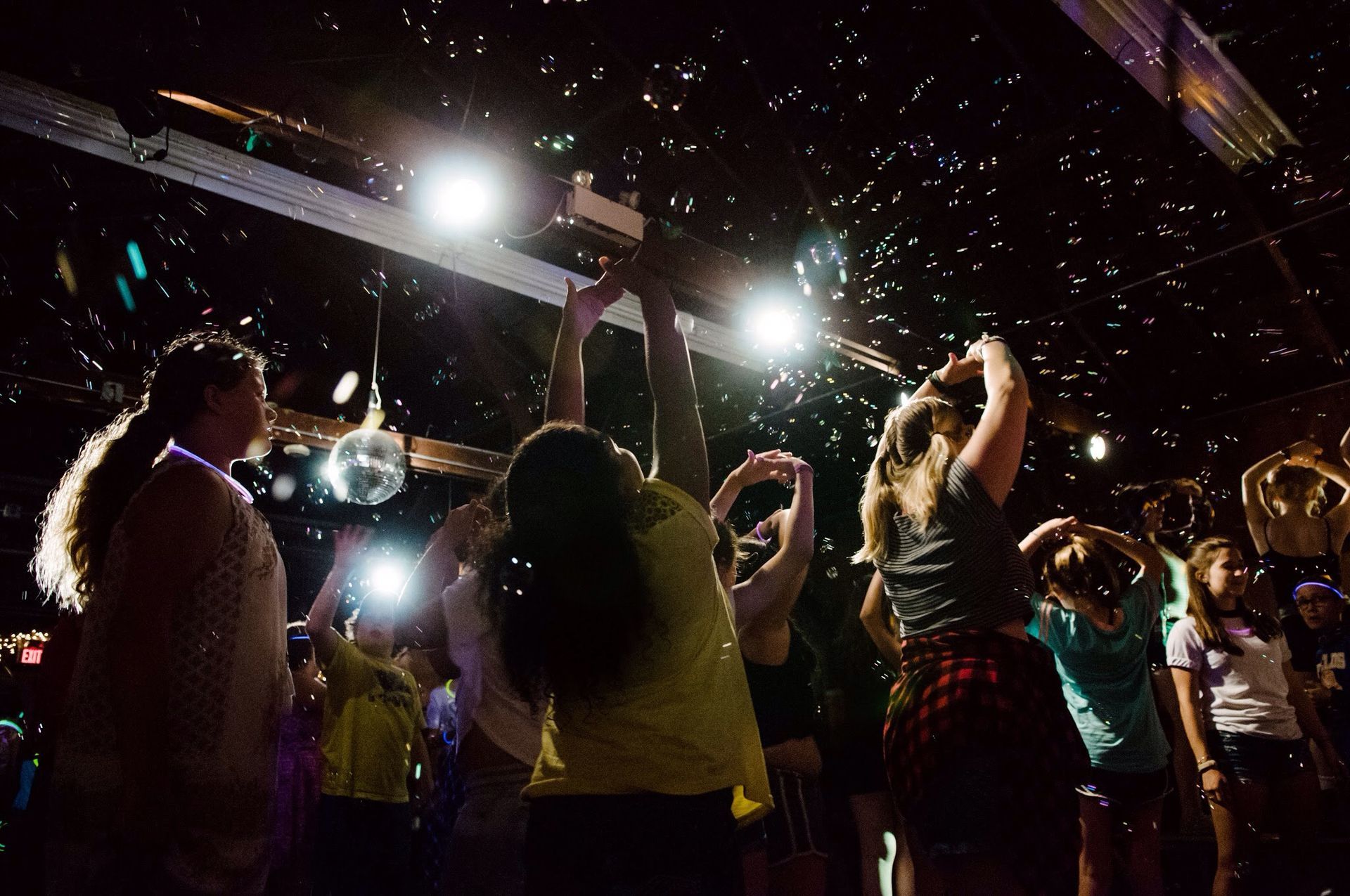 A group of people are dancing in a dark room.