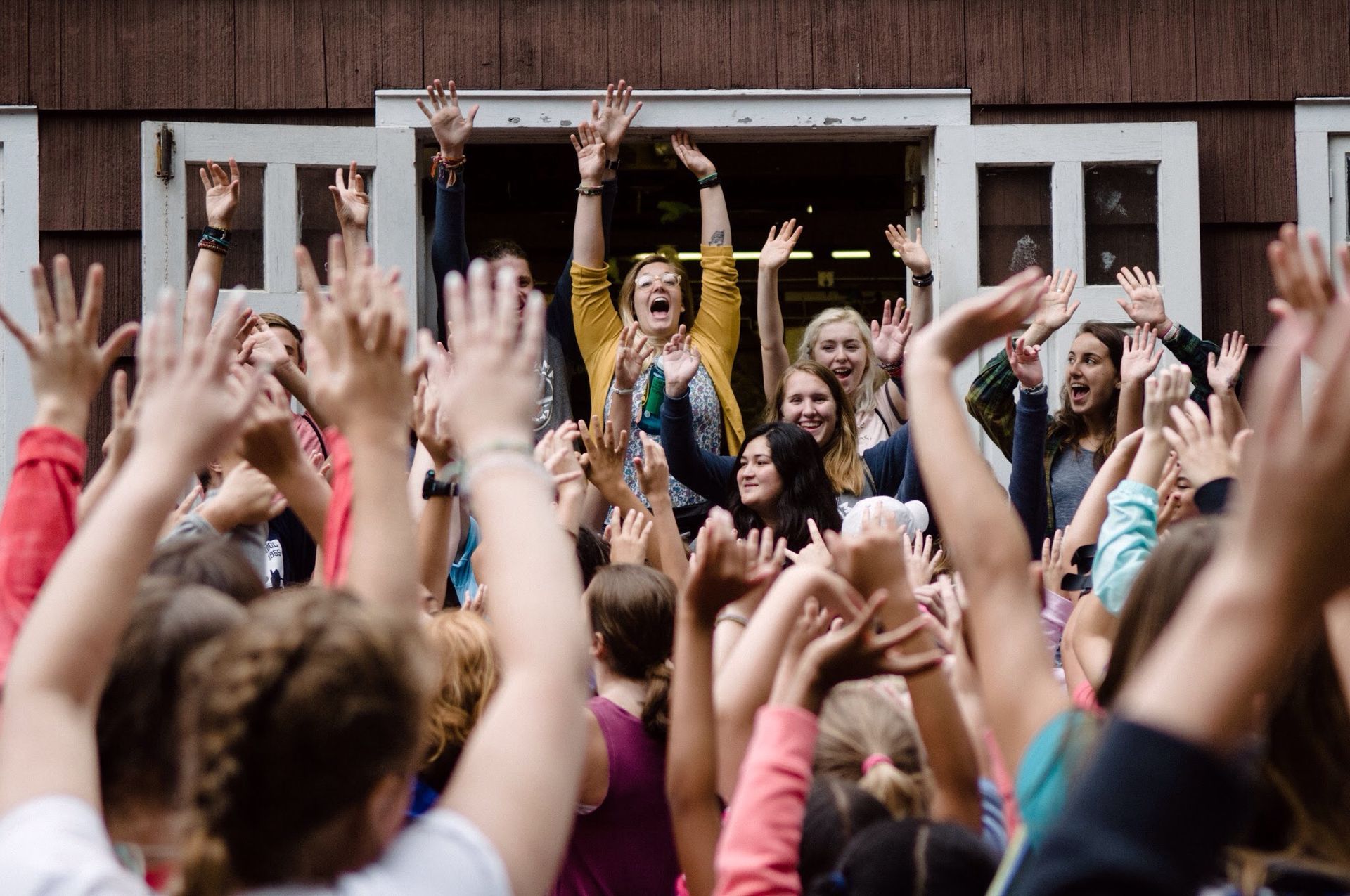 A group of people are raising their hands in the air.