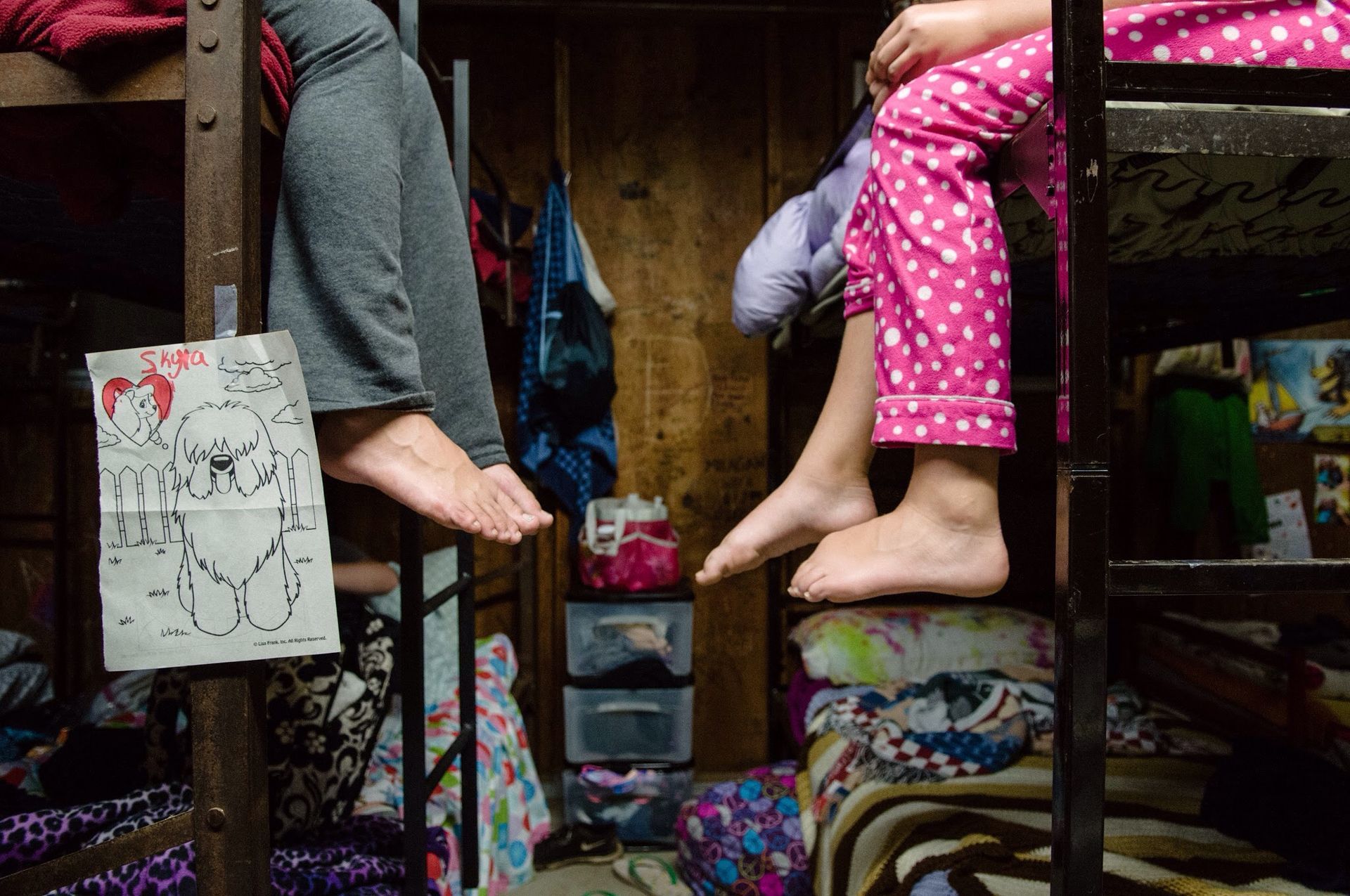 A group of children are sitting on bunk beds in a room.