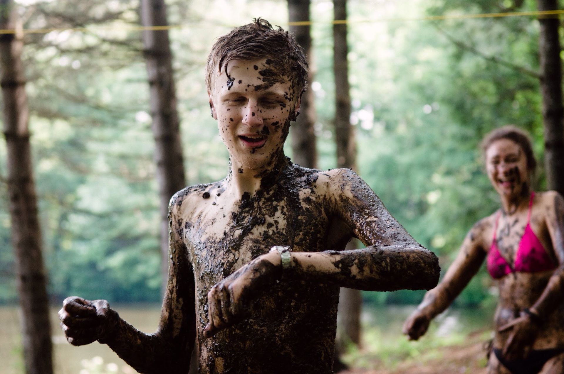 A boy and a woman are covered in mud.