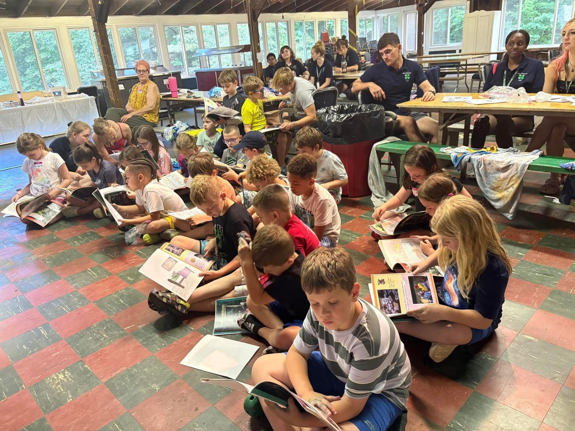 A group of children are sitting on the floor reading books.