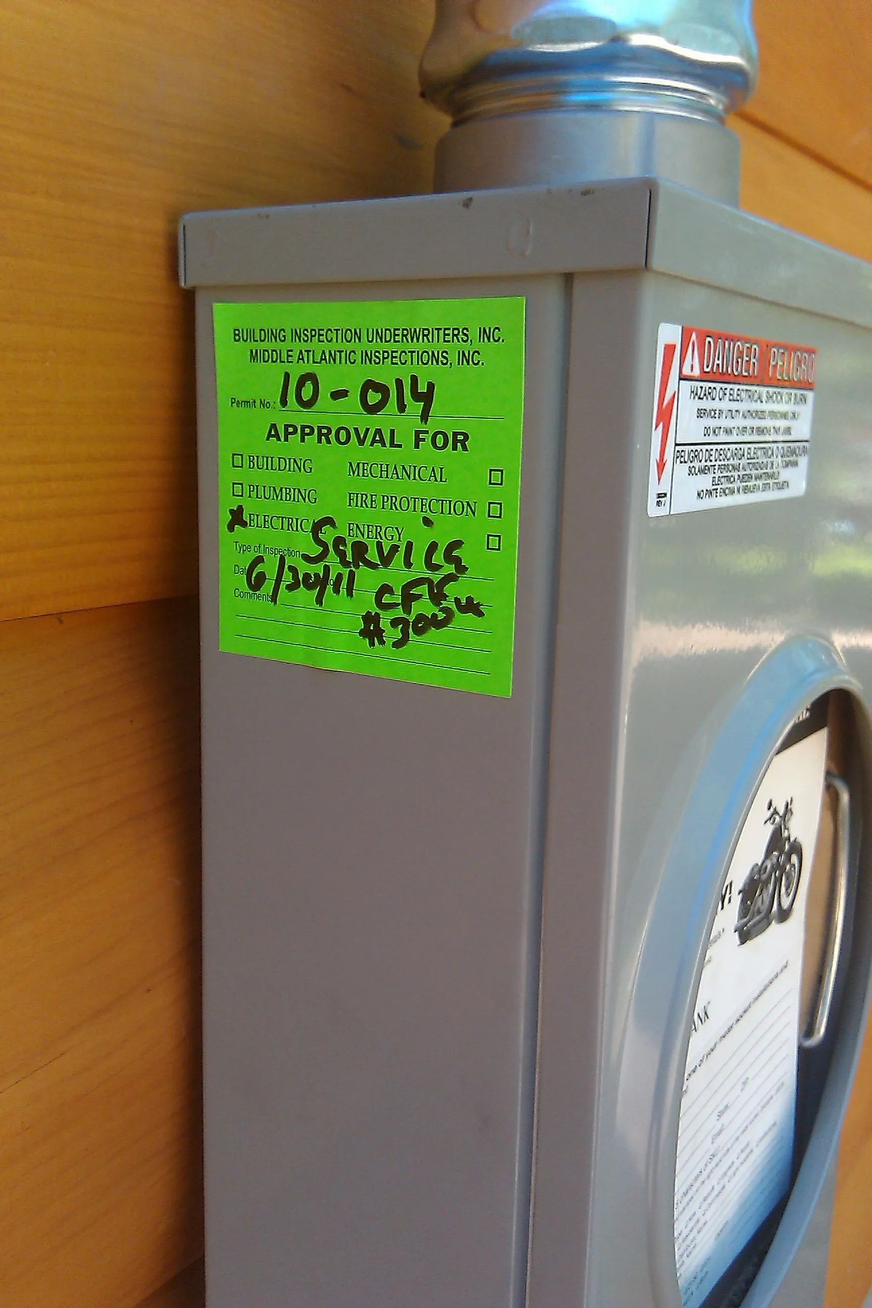 Electrical box with green sticker; indicates service approval.