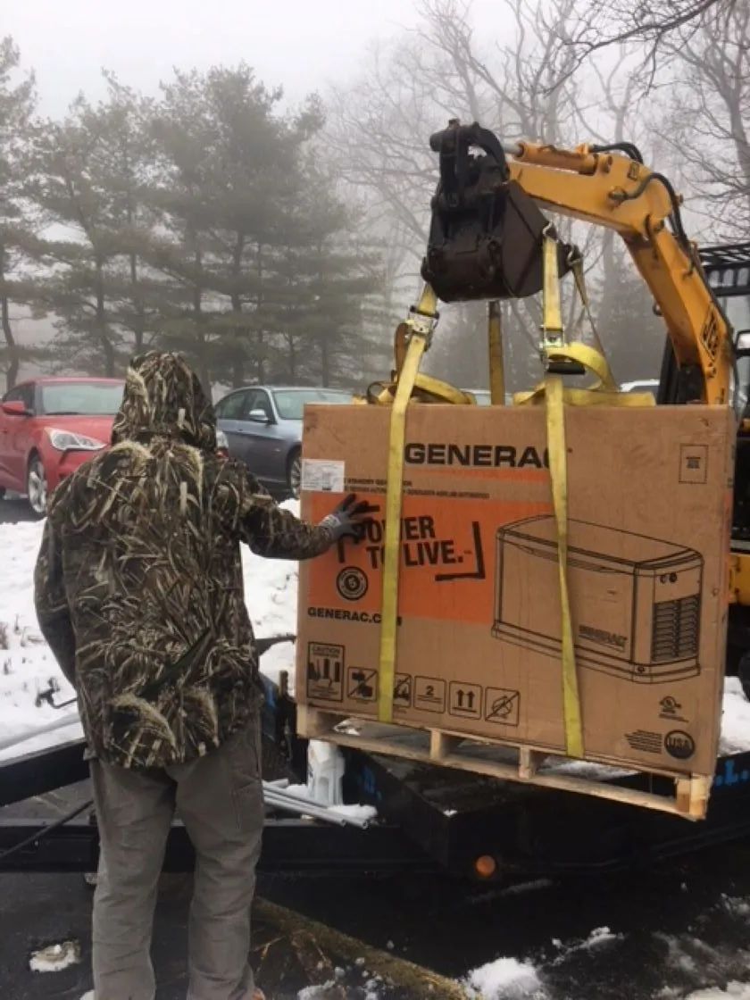 Person in camo directs a forklift lifting a boxed 