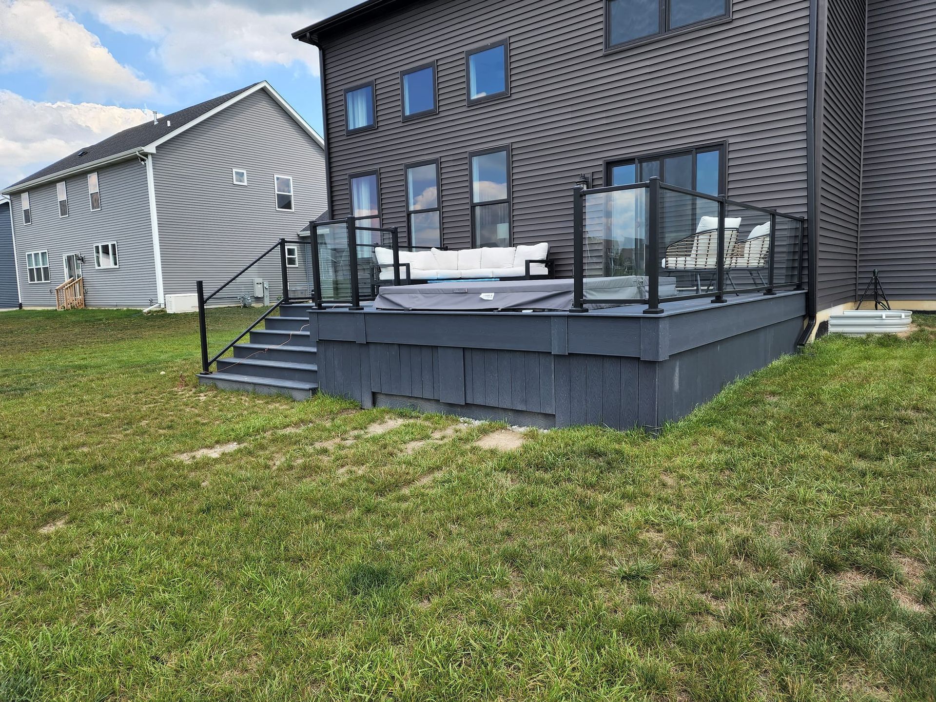 A large house with a large deck and stairs in front of it.