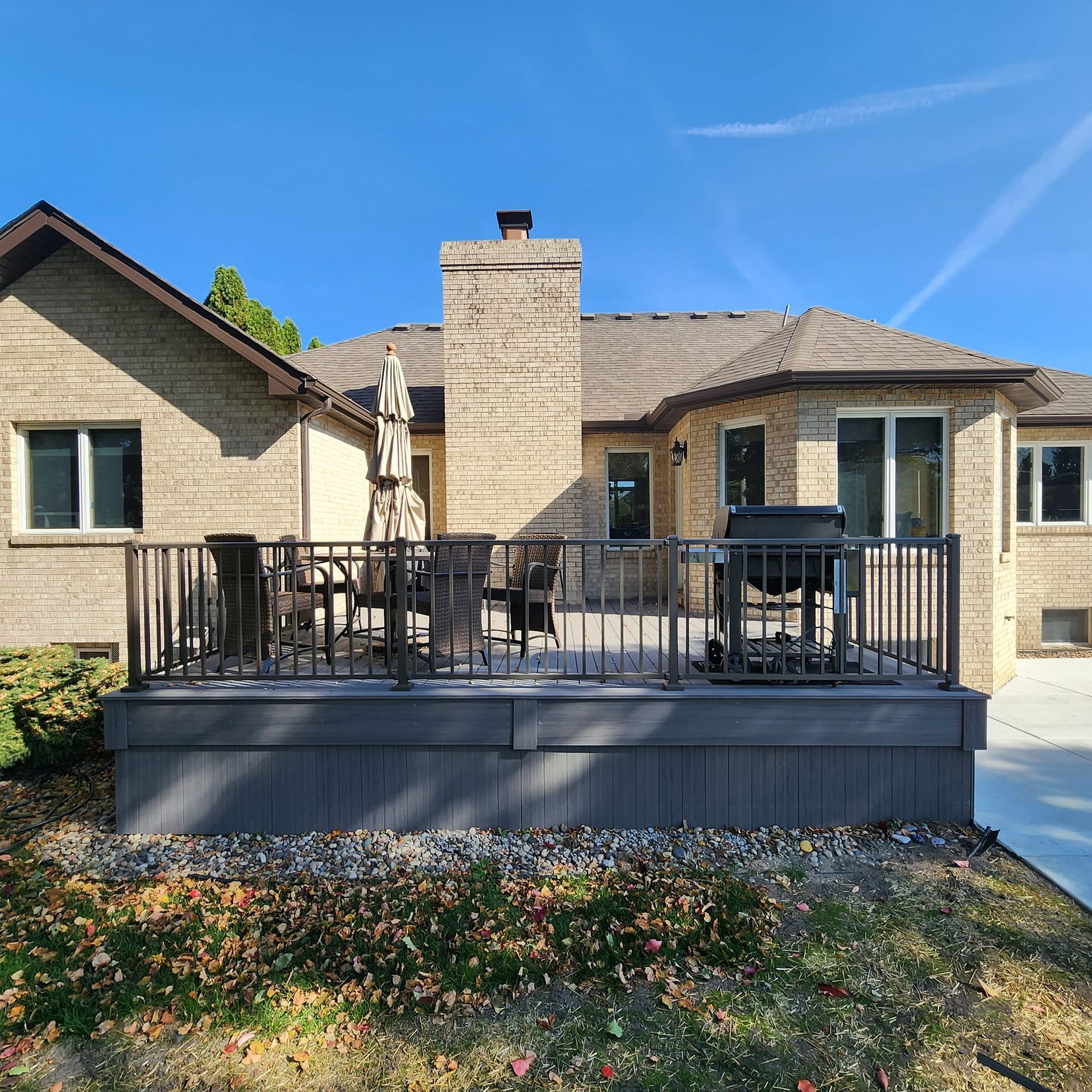A brick house with a large deck in front of it